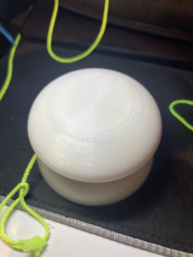 A white 3D-printed imperial-shaped rim fitted onto a yo-yo, with a lime green string