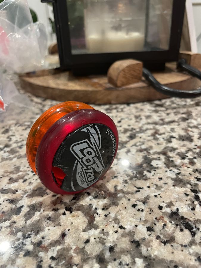 A repaired red and orange Yomega Loop 720 sitting on a granite counter