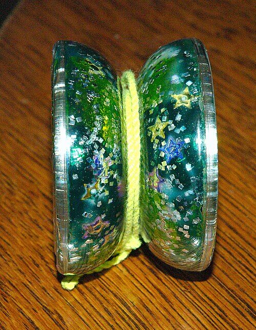 Clear green glitter yo-yo with flared butterfly-shaped halves and a yellow string