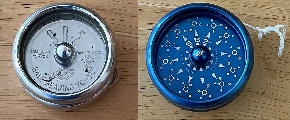 Two metal Tom Kuhn SB-2 yo-yos, one silver and one blue, seen face-on