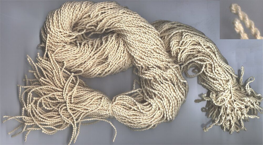 A tangled bundle of cotton yo-yo strings, with an inset of the twisted two-strand loop end