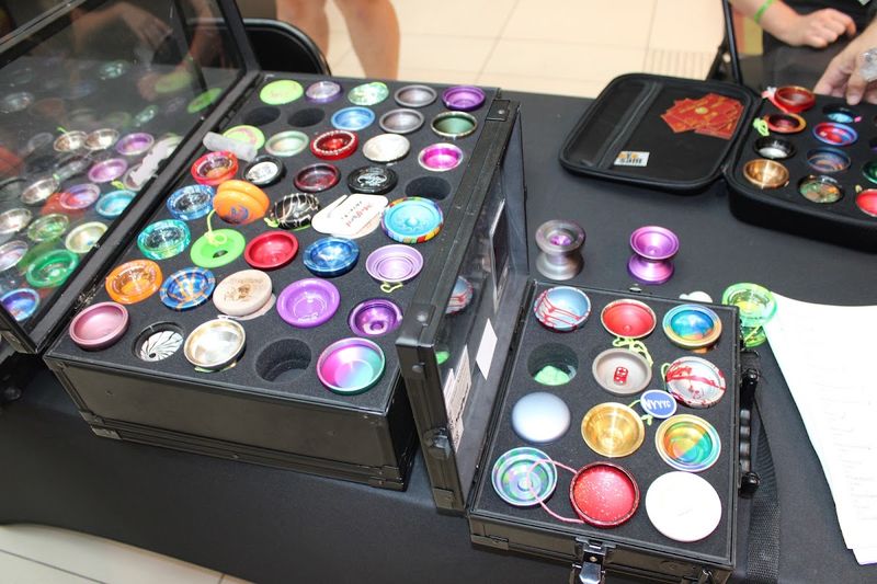 An open vendor case filled with brightly anodized metal yo-yos